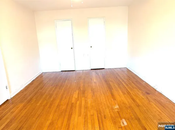 a view of a room with wooden floor