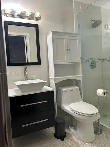 a bathroom with a toilet a sink and mirror