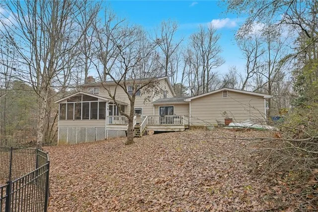 a front view of a house with a yard and large tree