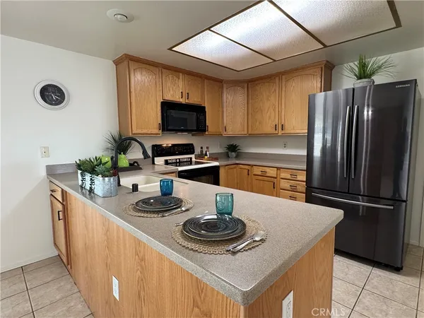 a kitchen with stainless steel appliances granite countertop a refrigerator a stove a sink dishwasher and a refrigerator