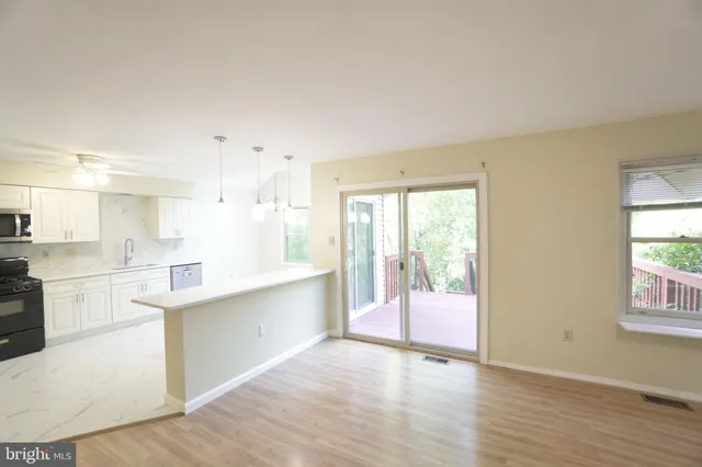 a large open kitchen with a refrigerator a sink dishwasher and a fireplace with wooden floor