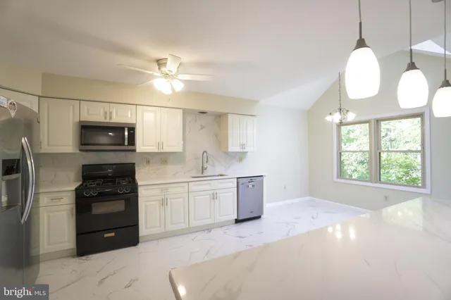 a kitchen with a stove a refrigerator and a sink