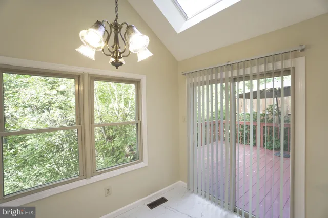 a view of a livingroom with a chandelier curtains and large windows