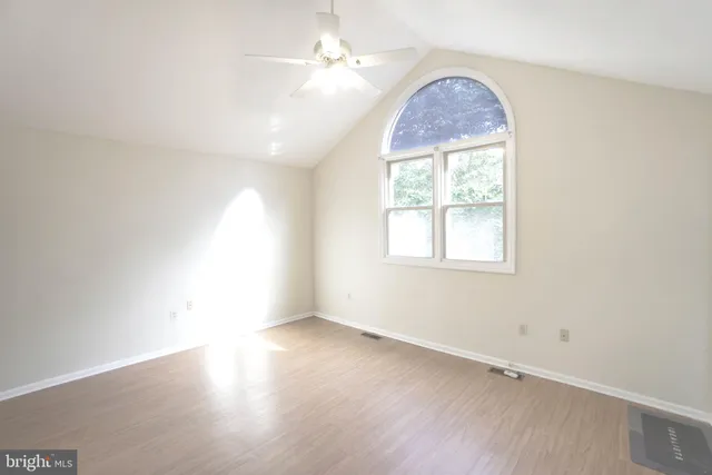 an empty room with a window and wooden floor