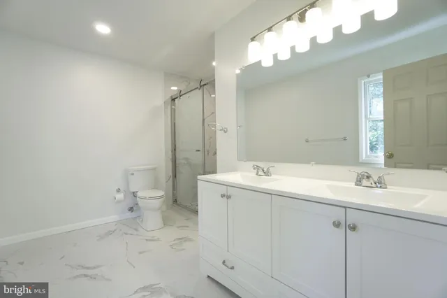 a bathroom with a double vanity sink mirror and shower