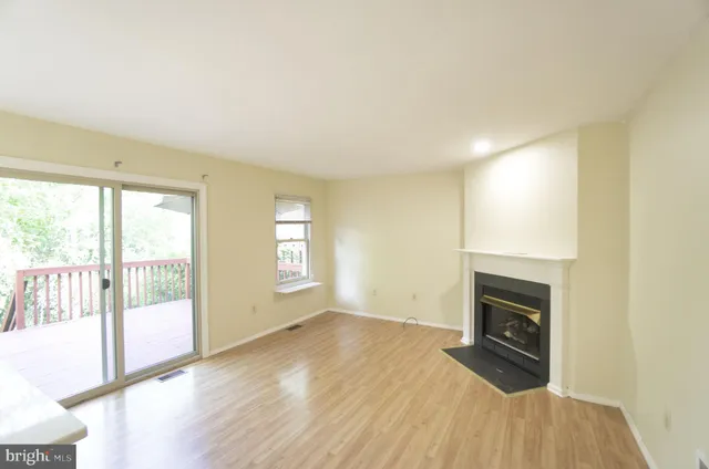 a view of empty room with wooden floor and fireplace