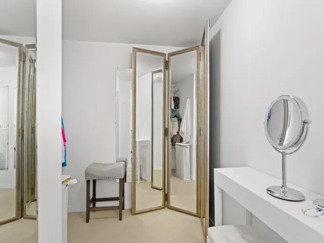 a bedroom with a bed a large window and walk in closet