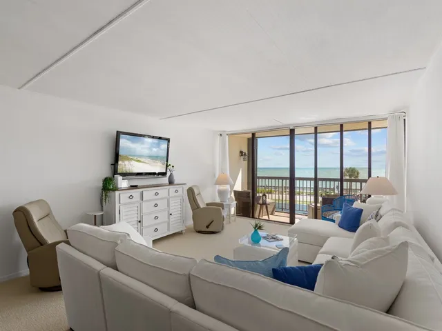 a living room with furniture and large windows