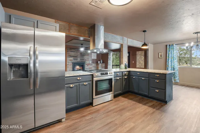 a kitchen with stainless steel appliances granite countertop a refrigerator a sink a stove and oven