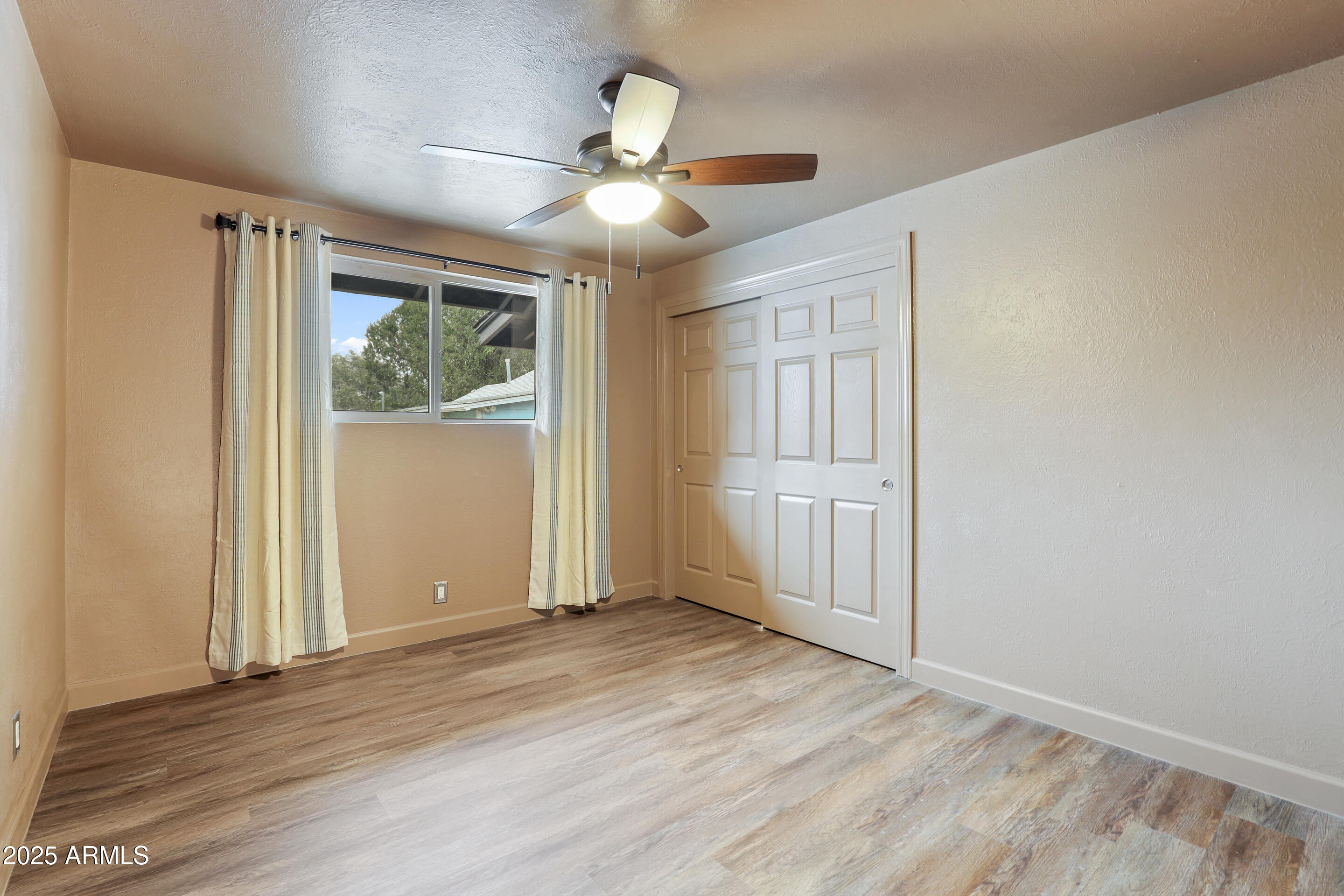 404 West Frontier Street Payson, AZ 85541 - Photo 20 of 39 an empty room with wooden floor chandelier fan and windows