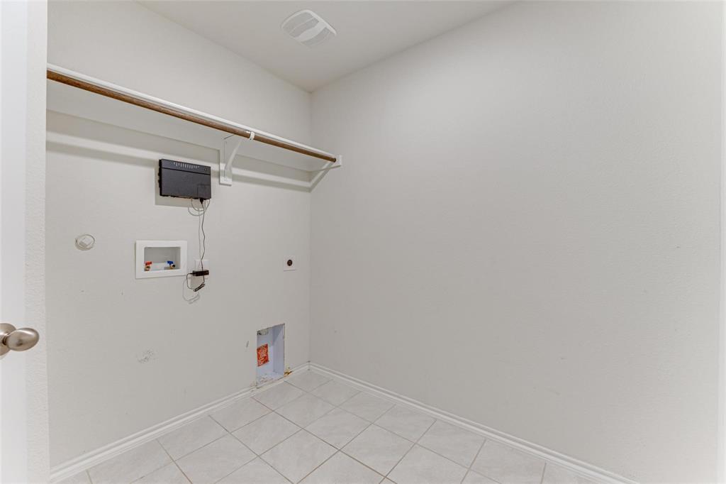 517 Milo Way Royse City, TX 75189 - Photo 13 of 34 Utility room with white tile flooring and baseboards, featuring a laundry hookup, wall-mounted control panel, and an upper storage shelf with a hanging rod