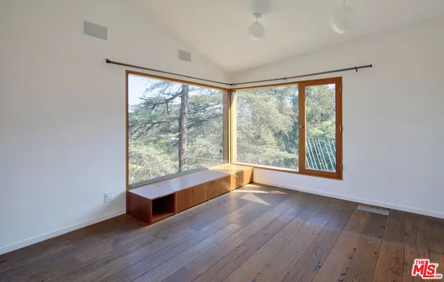 a view of a living room with a floor to ceiling window and wooden floor