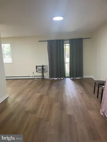 a view of empty room with wooden floor