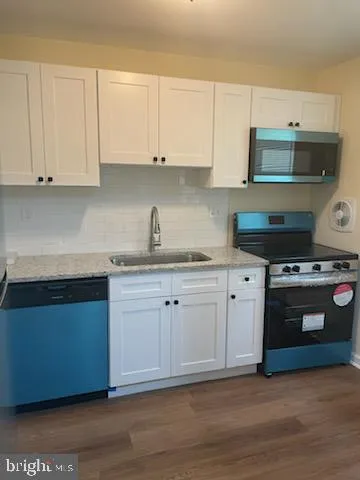 a kitchen with stainless steel appliances granite countertop a sink and a stove