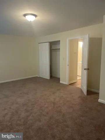 an empty room with closet and mirror