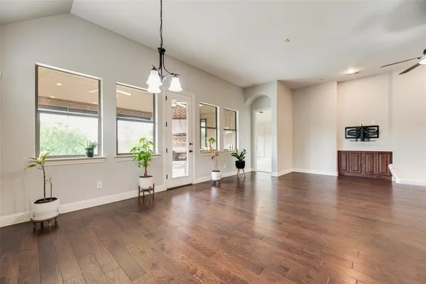 a view of empty room with wooden floor and window