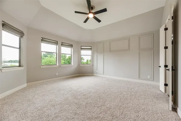 an empty room with fan and windows