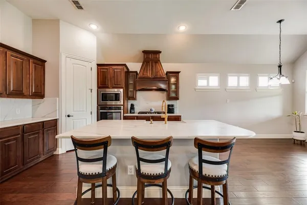 a kitchen with stainless steel appliances a sink a stove top oven a counter space and cabinets