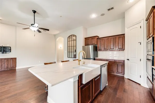 a kitchen with kitchen island a counter top space appliances and a window