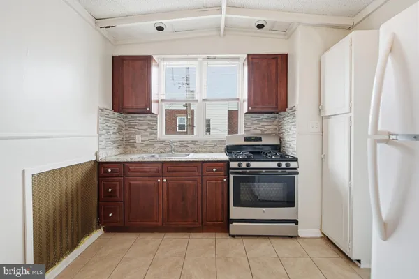 a kitchen with stainless steel appliances granite countertop a refrigerator and a stove