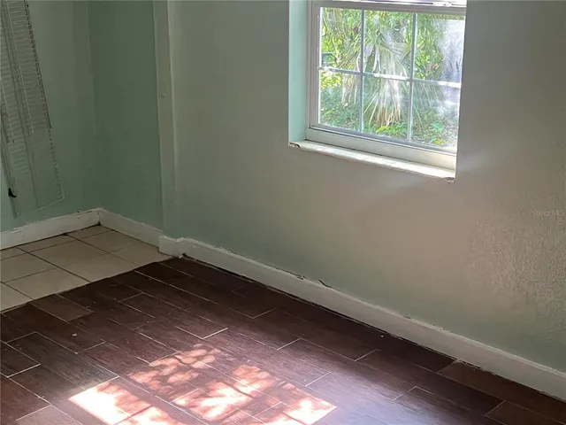 a view of a small space with wooden floor and a window