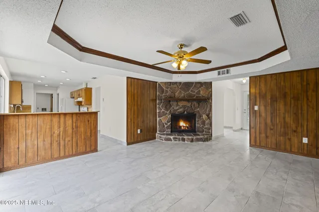 a view of an empty room with a fireplace and a window