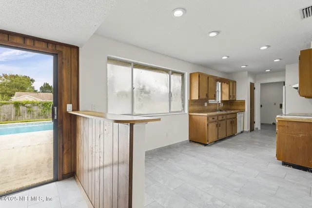 a view of kitchen with windows and refrigerator