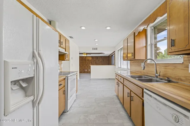 a kitchen with stainless steel appliances granite countertop a sink and a refrigerator
