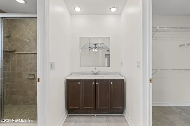 a bathroom with a granite countertop sink a mirror and shower