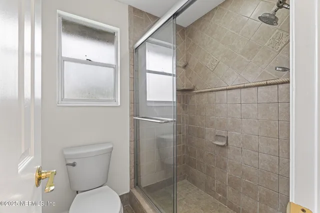 a bathroom with a toilet and a shower