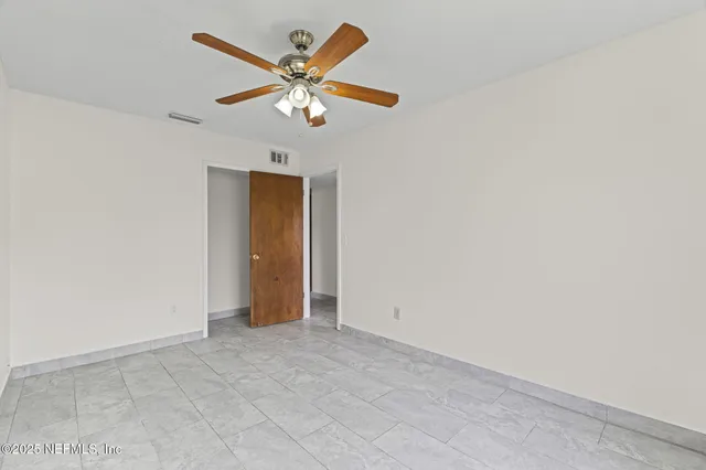 an empty room with a fan and a fan