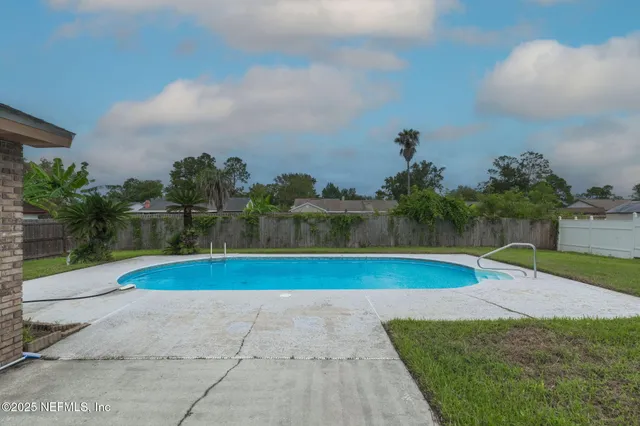 a view of a house with a yard and palm trees