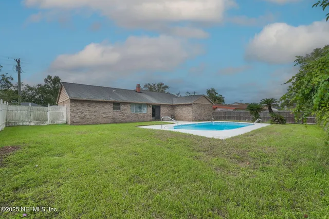 a view of a backyard with swimming pool