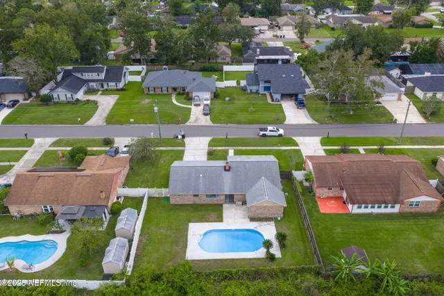 an aerial view of a house with swimming pool outdoor seating and yard