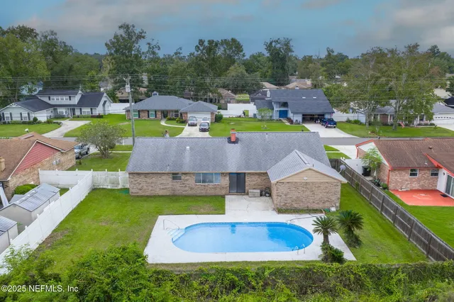 an aerial view of a house with swimming pool and big yard