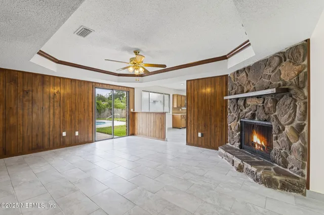 a view of an empty room with a fireplace and a window