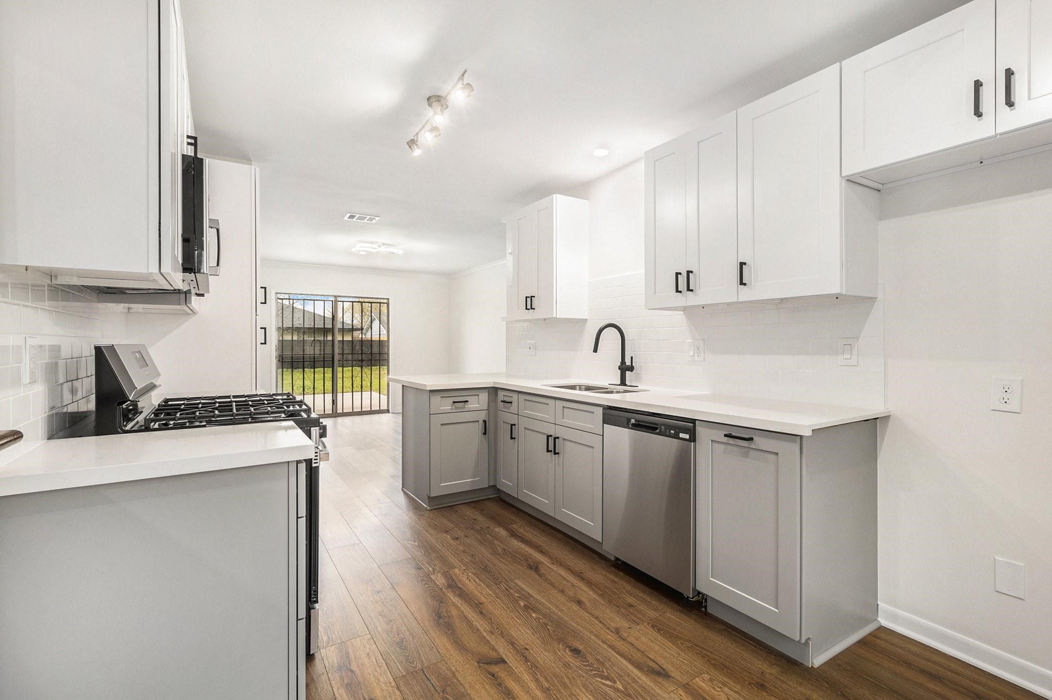 1510 Tarberry Road Houston, TX 77088 - Photo 5 of 19 a kitchen with granite countertop white cabinets and white appliances