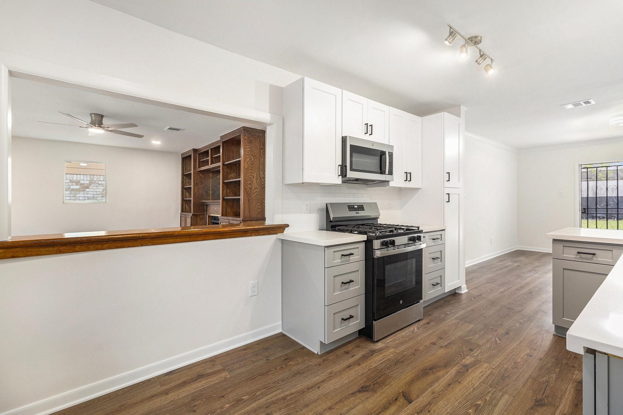 1510 Tarberry Road Houston, TX 77088 - Photo 6 of 19 a kitchen with stainless steel appliances a stove top oven a sink a refrigerator white cabinets and wooden floor