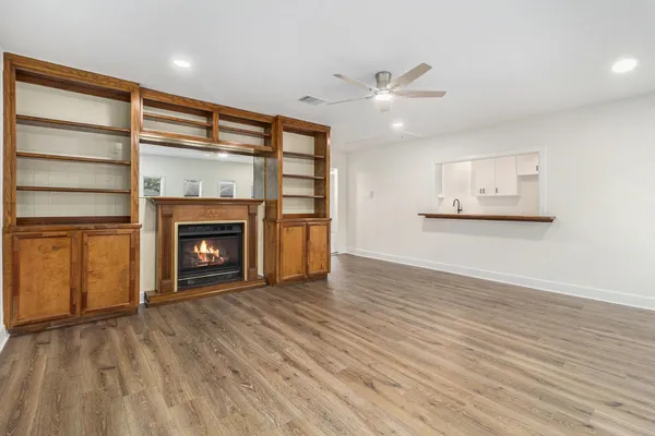 a view of empty room with wooden floor and fireplace