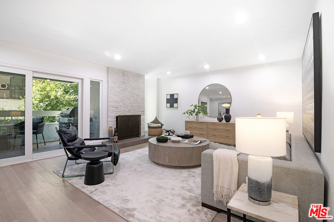 a living room with furniture a fireplace and a floor to ceiling window