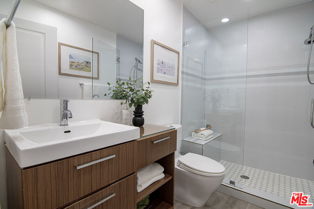 1887 Greenfield Avenue, Unit 110 Los Angeles, CA 90025 - Photo 14 of 18 a bathroom with a sink mirror vanity and toilet