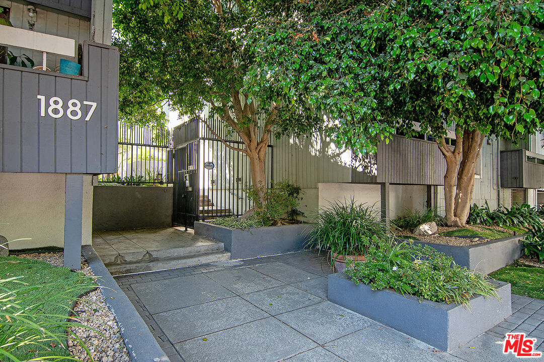 1887 Greenfield Avenue, Unit 110 Los Angeles, CA 90025 - Photo 18 of 18 a view of a patio with table and chairs potted plants and large tree