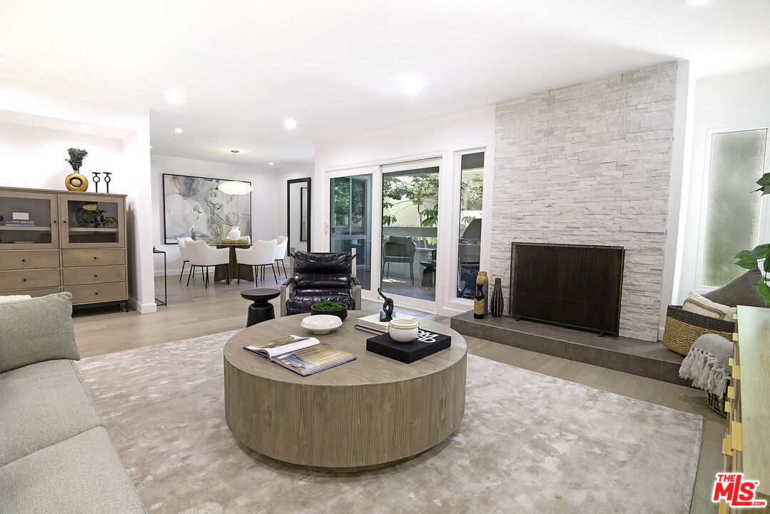 1887 Greenfield Avenue, Unit 110 Los Angeles, CA 90025 - Photo 3 of 18 a living room with furniture and a fireplace