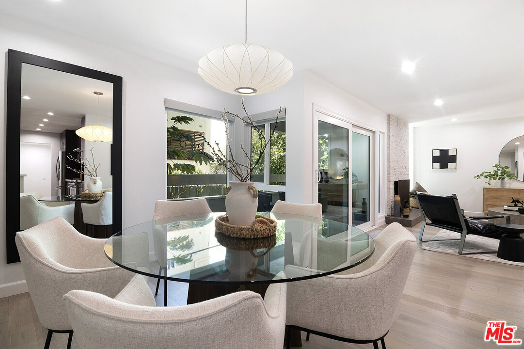 1887 Greenfield Avenue, Unit 110 Los Angeles, CA 90025 - Photo 5 of 18 a living room with furniture a table and chairs