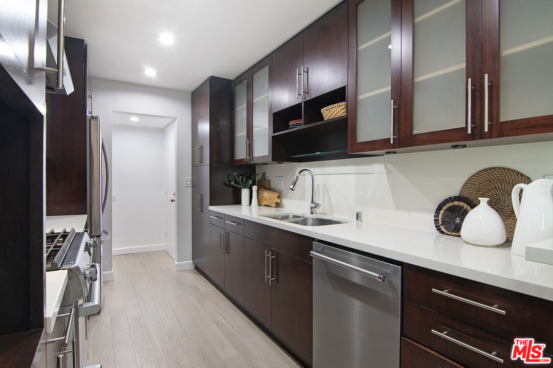 1887 Greenfield Avenue, Unit 110 Los Angeles, CA 90025 - Photo 7 of 18 a kitchen with a sink stainless steel appliances and cabinets