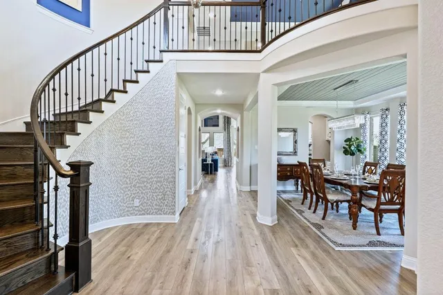 a view of a hallway with dining room and wooden floor