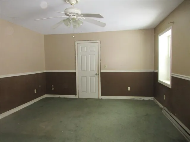 an empty room and chandelier fan in a room