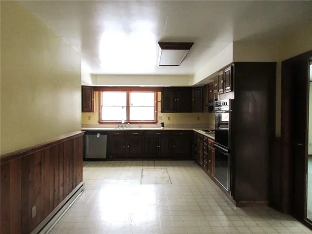 a kitchen with stainless steel appliances a refrigerator and a window