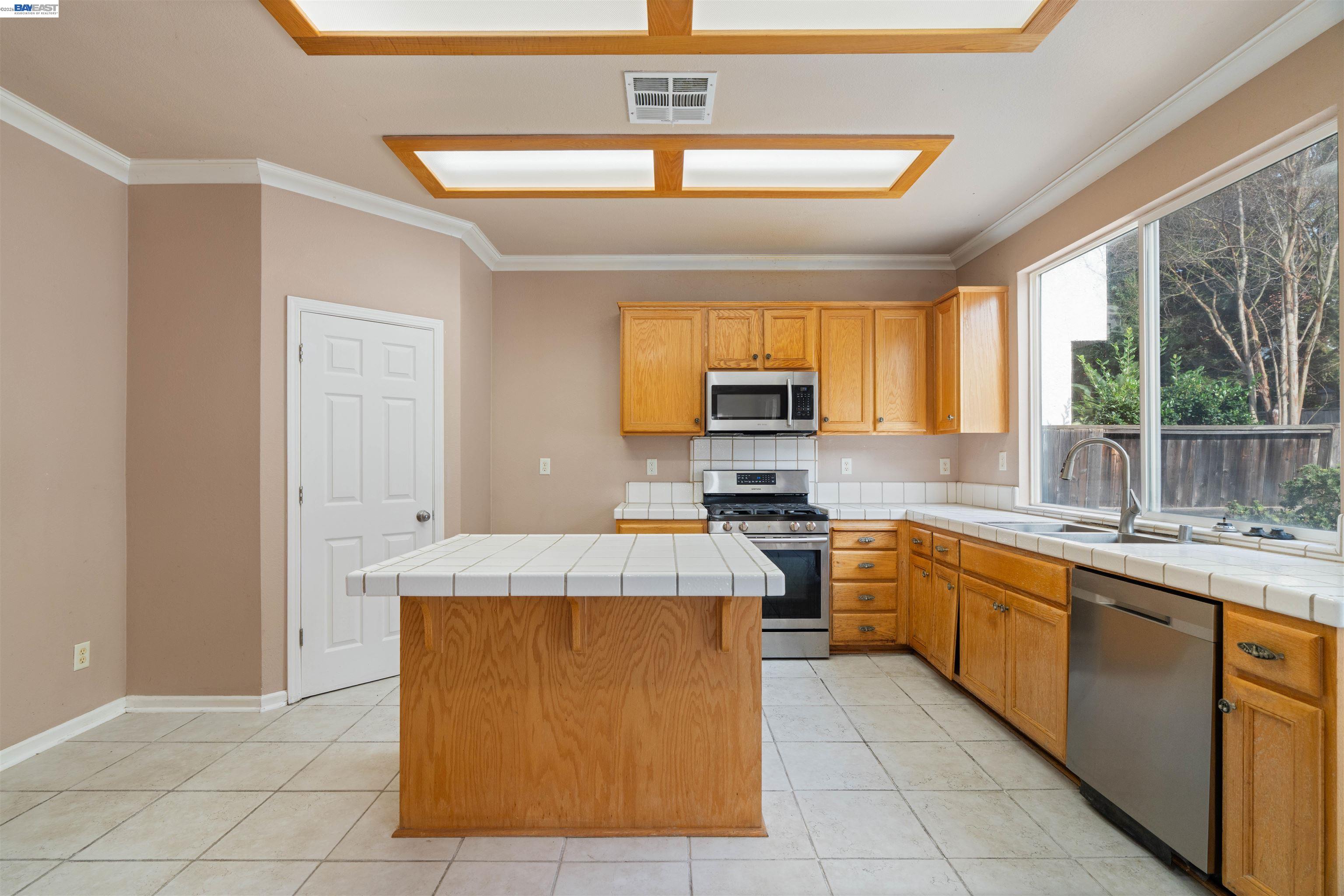 4925 Bay View Circle Stockton, CA 95219 - Photo 8 of 47 a kitchen with stainless steel appliances granite countertop a sink counter space cabinets and a large window