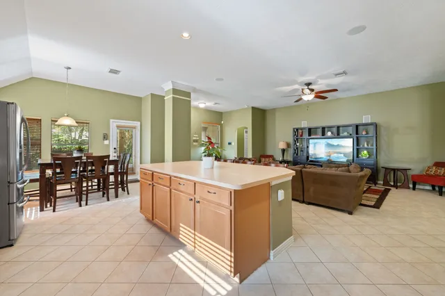 a large white kitchen with a large island in the center